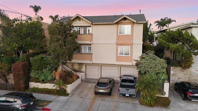 Exterior of the gated Villa Terrace condominium building at 3745 Villa Terrace in North Park at dusk, with balconies above a row of garages